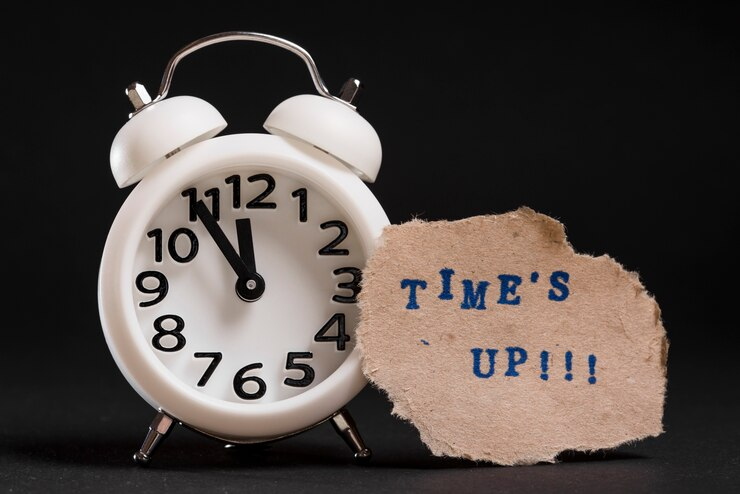 alarm clock with a sign saying "time's up" - represents the notion of setting reminders for deadlines, for ADHD people especially when they're managing ADHD in their careers