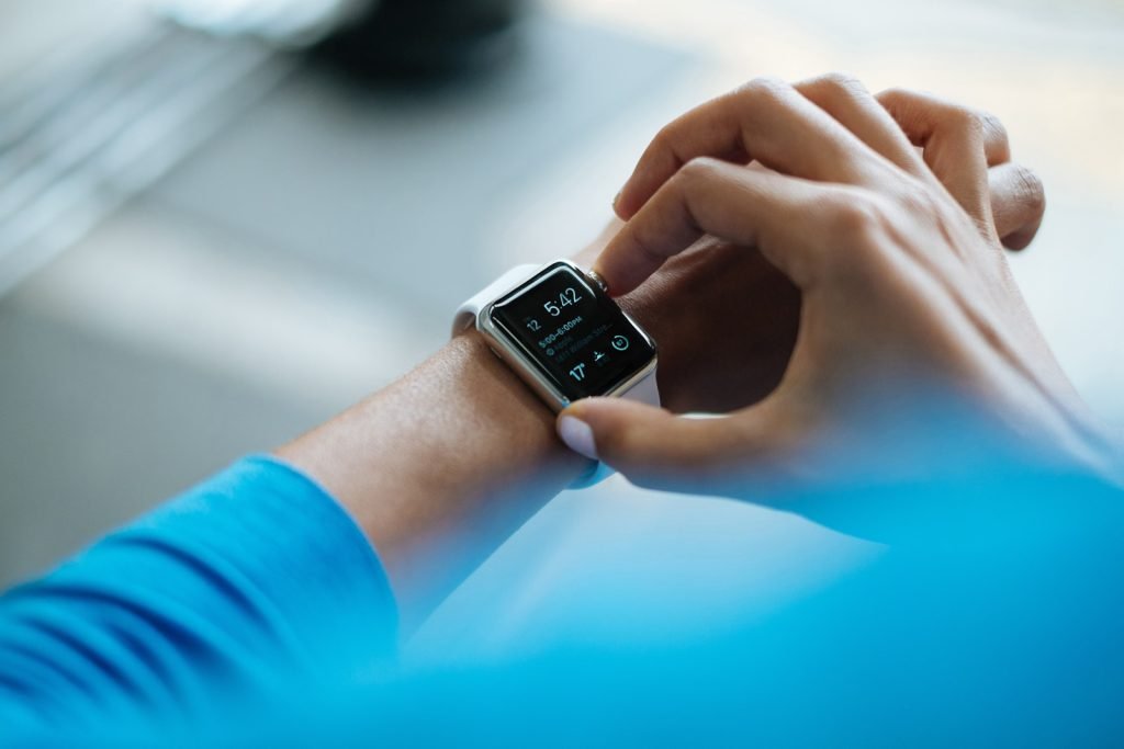 represents time management person clicking Apple Watch smartwatch, representing time management