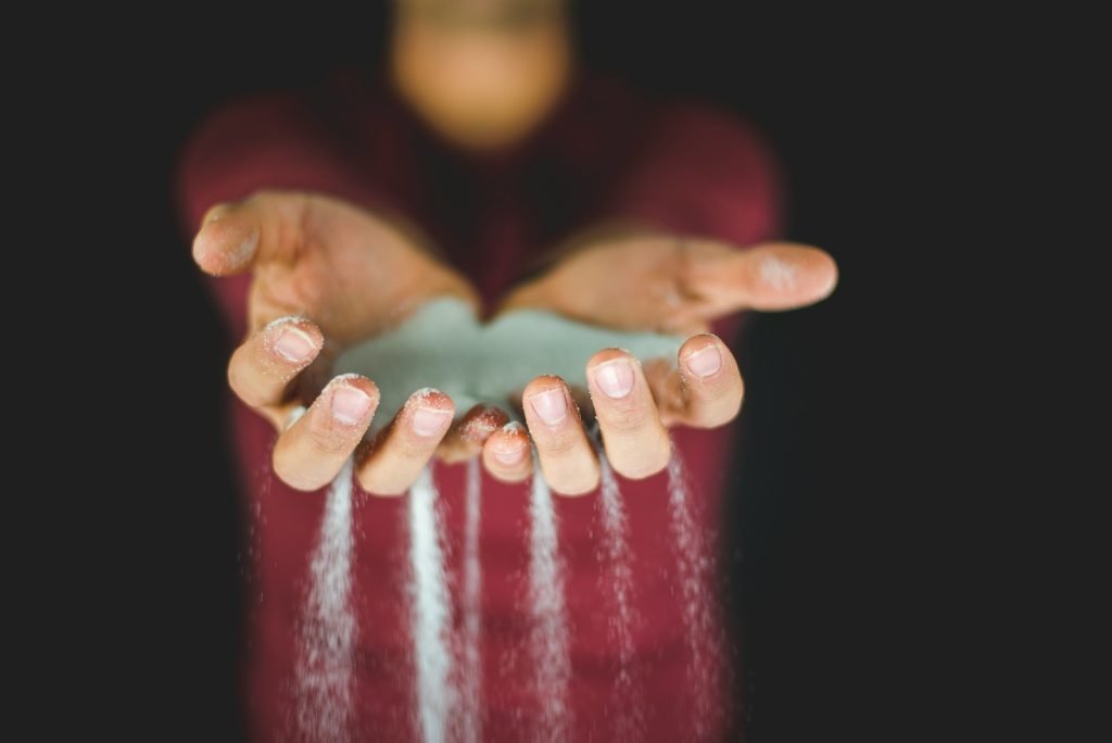 cupped hands with sand running through fingers to indicate running out of time