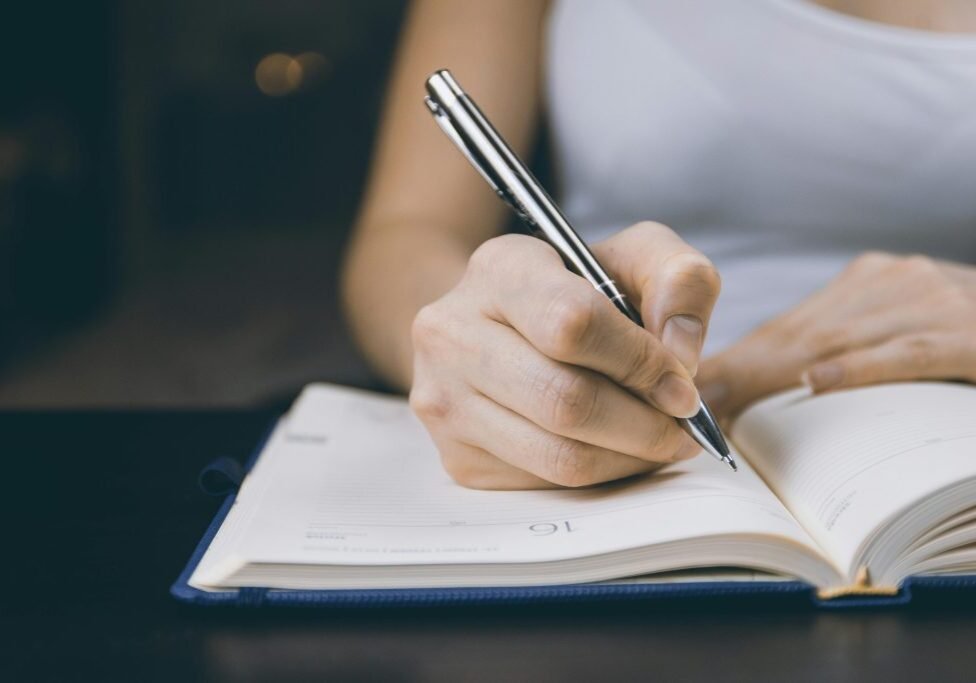 woman writing in notebook woman writing in notebook